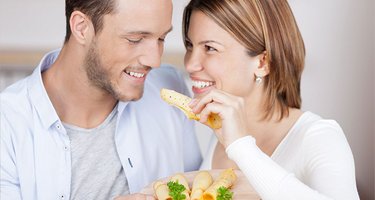 Glückliches junges Paar isst Käse