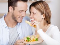 Glückliches junges Paar isst Käse