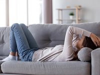 Trauriges Mädchen liegt auf dem Sofa und starrt an die Decke