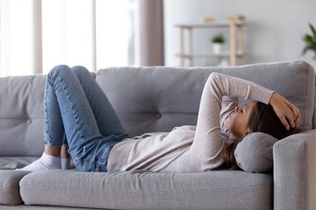 Trauriges M&auml;dchen liegt auf dem Sofa und starrt an die Decke