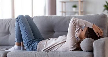 Trauriges Mädchen liegt auf dem Sofa und starrt an die Decke