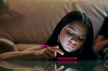 M&auml;dchen h&auml;ngt nachts am Smartphone