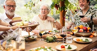 Gut gelaunte Senioren essen mediterrane Kost