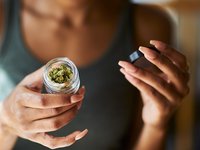 Junge Frau zeigt Glas mit medizinischem Cannabis