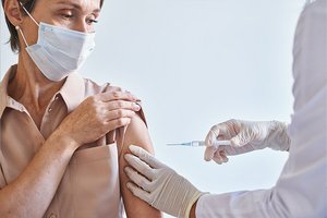 Rund 60 Jahre alte Frau wird geimpft
